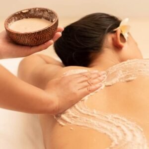 Balinese body mask being applied on a woman's back during a spa treatment.